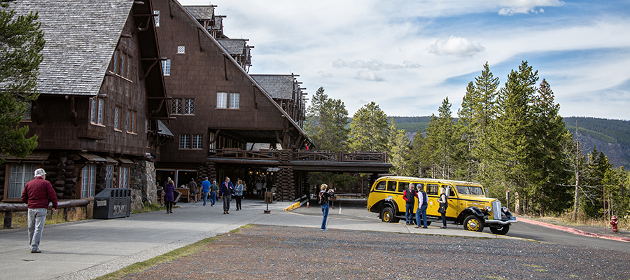 Yellow bus parked in front of Old Faithful Inn.